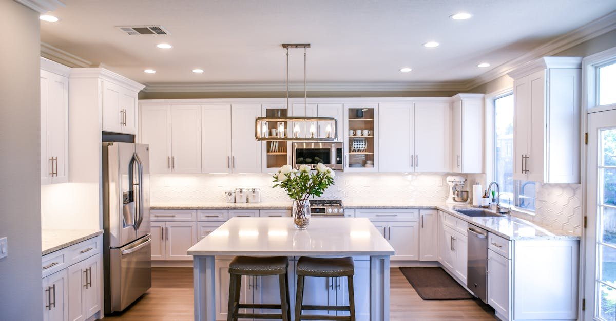 Spacious and elegant kitchen featuring white cabinetry, island, and stainless steel appliances.